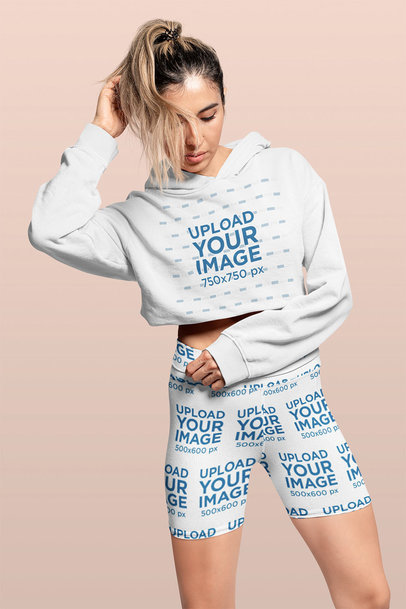 Crop Top Hoodie and Bike Shorts Mockup Featuring a Woman Posing in a Studio