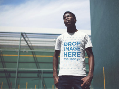 Young Man Wearing a Short Sleeved T-Shirt While Staring At The Sun In a Fronton Court Mockup
