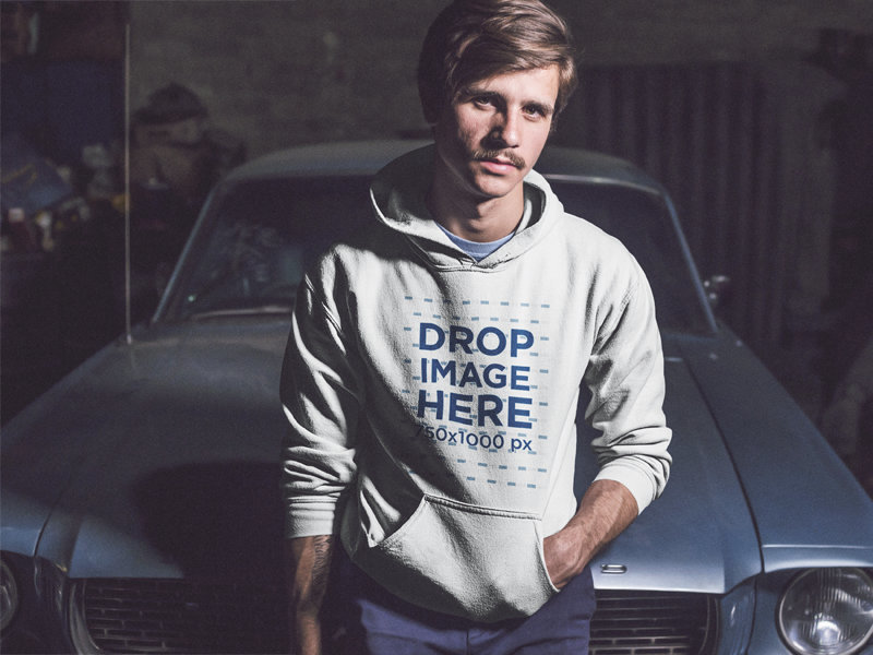 Serious Young Man Wearing a Pullover Hoodie While Sitting Against a Vintage Mustang Mockup