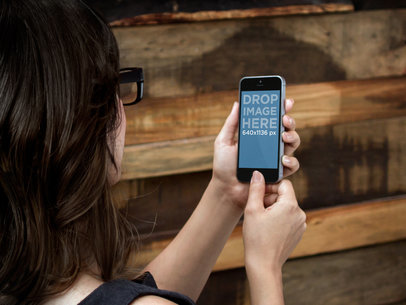 Over-the-Shoulder Mockup of a Woman Checking Her iPhone in Portrait Position