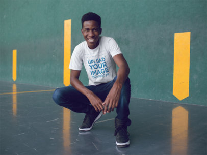 Smiling Young Man Crouching While Wearing a Round Neck T-Shirt