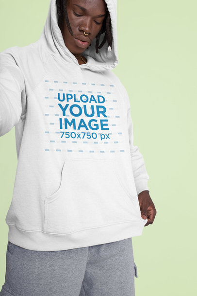 Mockup of a Man Taking a Selfie with a Hoodie in a Studio