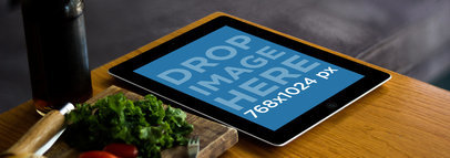 Mockup of a Black iPad Over a Wooden Bistro Table 