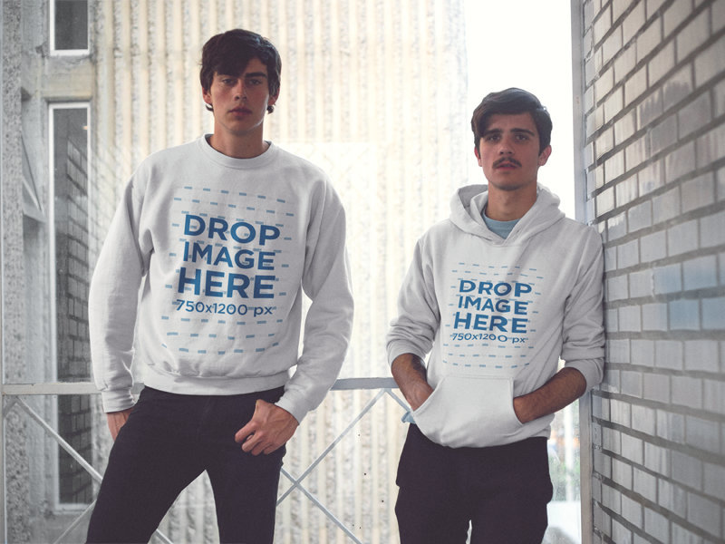 Mockup of Two Friends Wearing a Pullover Hoodie and a Crewneck Sweatshirt with Matching Colors and Designs