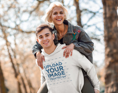 Mockup of a Young Man with a Pullover Hoodie Posing with His Girlfriend in the Woods