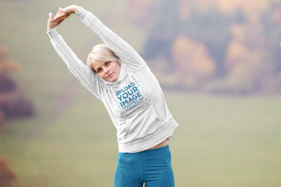 Hoodie Mockup of a Woman Stretching Before Running in the Outdoors