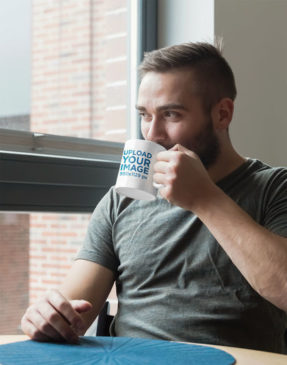 11 oz Mug Mockup Featuring a Bearded Man at a Table 