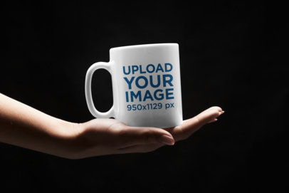 Mockup of a Woman Holding an 11 oz Mug in the Dark 