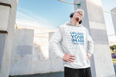 Hoodie Mockup Featuring a Man With Headphones Stretching His Neck 