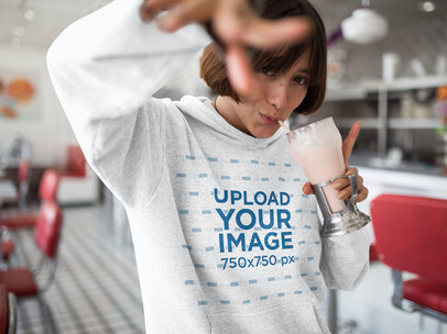 Template of a Short Haired Woman Drinking a Milkshake While Wearing a Pullover Hoodie in a Restaurant