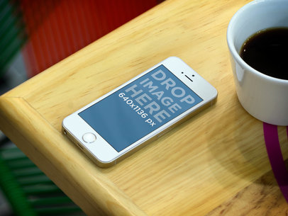 Mockup of an iPhone 5S Lying over a Restaurant Table