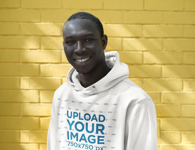 Hoodie Mockup of a Man Standing in Front a Yellow Brick Wall 39688-r-el2