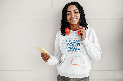 Pullover Hoodie Mockup of a Woman Listening to Music on Her Phone 