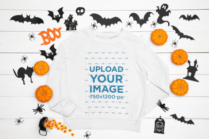Mockup of a Flat Laid Sweatshirt Featuring a Halloween Decoration
