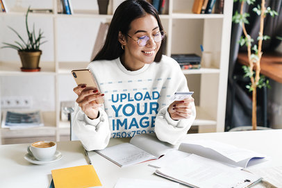 Mockup of a Woman with a Sweatshirt Doing Online Shopping at Home 