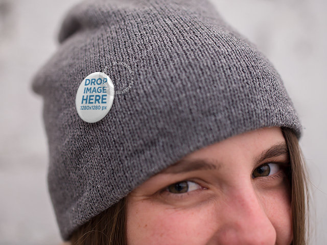 Mockup of a Woman Wearing a Button on a Grey Beanie