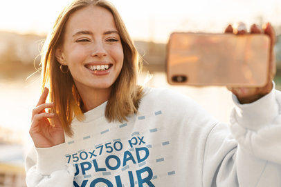 Crewneck Sweatshirt Mockup Featuring a Happy Young Woman Taking a Selfie 