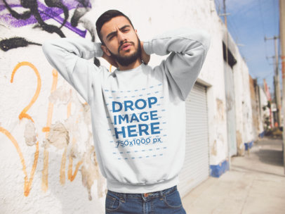 Mockup of an Hispanic Man Wearing a Crewneck Sweatshirt While Doing Faces in the Street