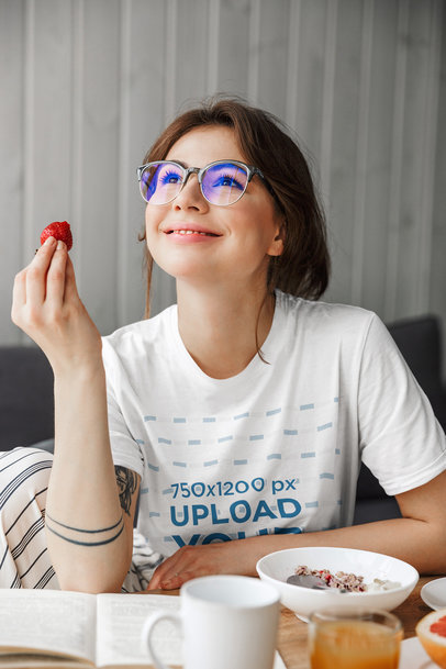 T-Shirt Mockup of a Woman With Glasses Eating Breakfast