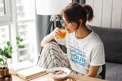 T-Shirt Mockup of a Woman Reading While Having Breakfast