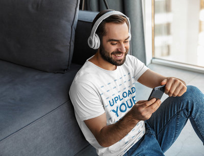 Mockup of a Man Wearing a T-Shirt While Listening to Music at Home