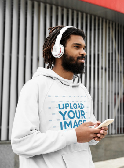Mockup of a Man with a Hoodie and Headphones Walking on the Street