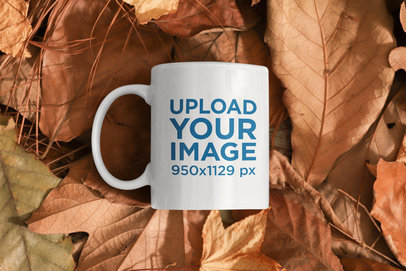 Mockup Featuring an 11 oz Coffee Mug Laid on a Bunch of Fall Leaves m137