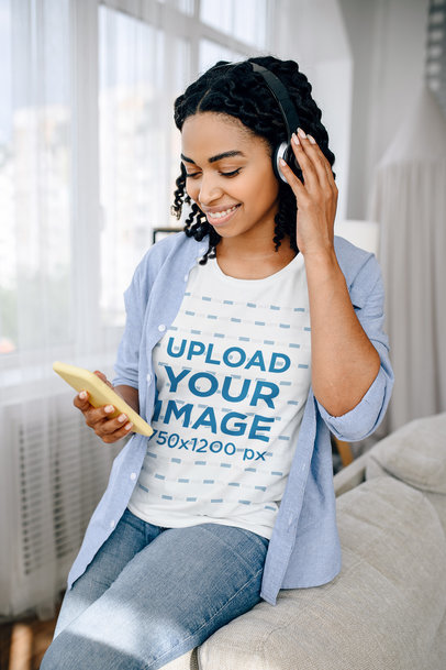 Tee Mockup of a Woman at Home Listening to Music on Her Phone 