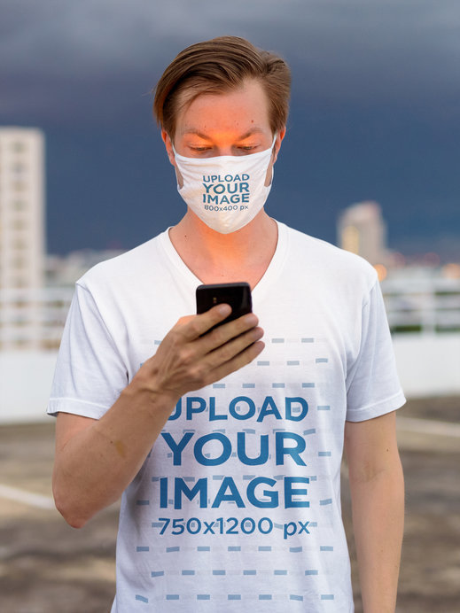 T-Shirt and Face Mask Mockup of a Man Standing on a Rooftop