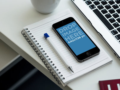 iPhone 5S Mockup Featuring a Notebook on a Desk
