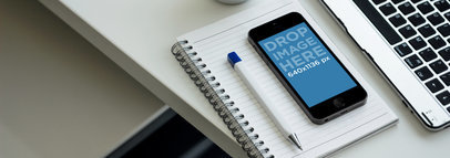 Mockup of a Space Grey iPhone 5S over a Notebook