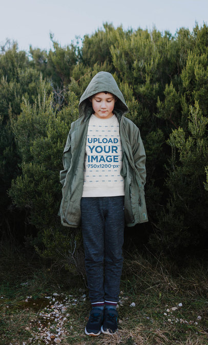 Sweatshirt Mockup Featuring a Boy Standing in Front of Some Bushes 