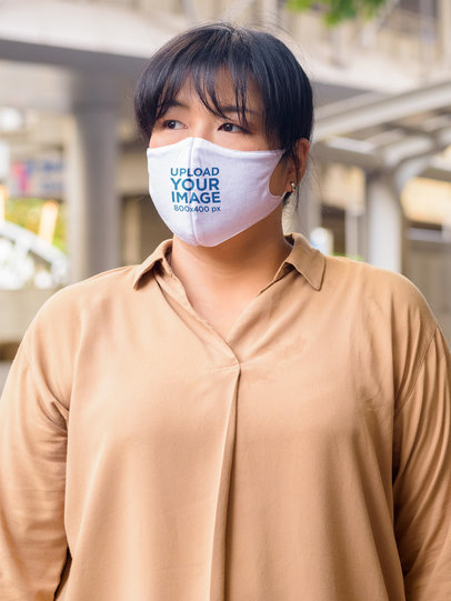 Mockup of a Serious Woman Wearing a Face Mask on the Street