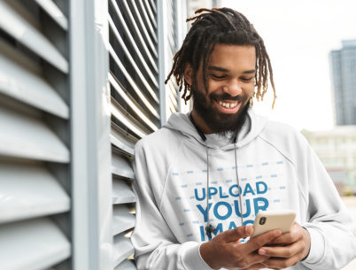 Hoodie Mockup Featuring a Man Reading a Funny Message on His Phone 