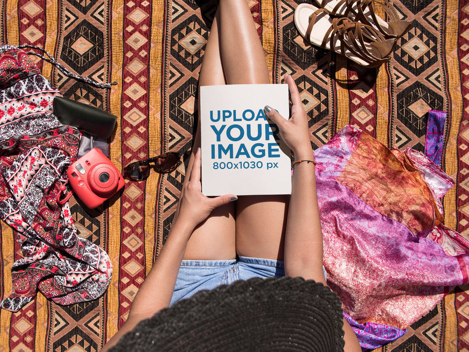 Tanned Woman Holding a Book on her Lap While Sitting Down at the Beach Mockup