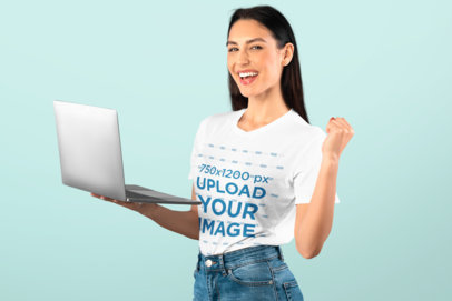 T-Shirt Mockup of a Woman Holding a Computer in a Studio