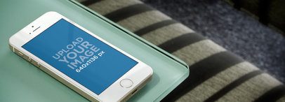 Wide Mockup of a Gold iPhone 5S over a Textured Surface