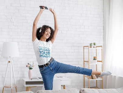 T-Shirt Mockup Featuring a Young Happy Woman Dancing at Home