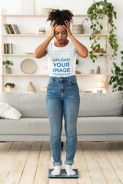 T-Shirt Mockup of a Surprised Woman Standing on a Scale