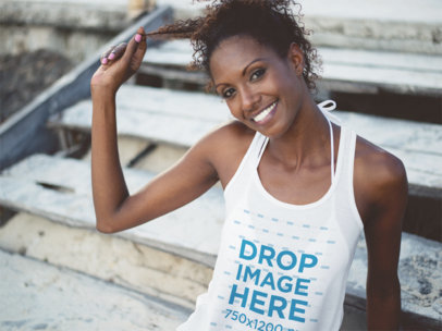 Mockup of a Smiling Woman Wearing a Tank Top by a Stairway
