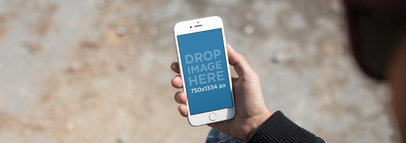 Over-the-Shoulder Mockup of a Woman Holding an iPhone 6 in Front of Her