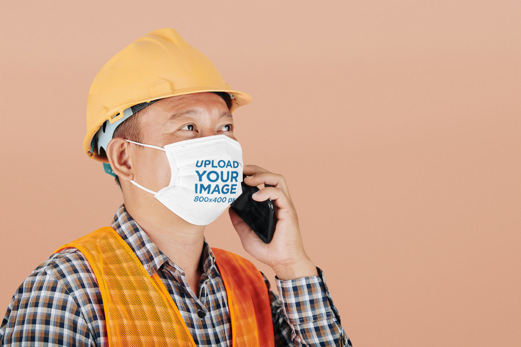 Face Mask Mockup Featuring a Man With a Construction Helmet at a Studio
