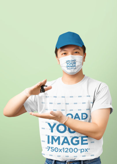 T-Shirt and Face Mask Mockup of a Man Holding a Bottle of Sanitizer