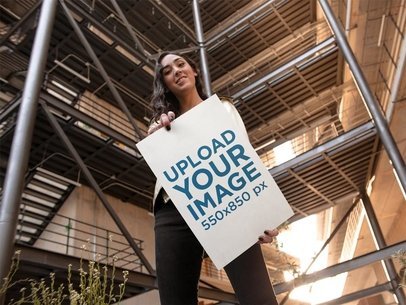 Young Woman Holding a Big Poster While in a Building Mockup