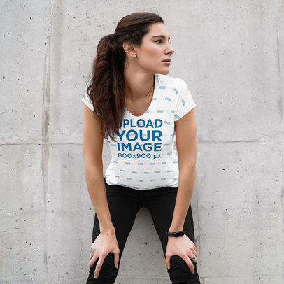 Sublimated T-Shirt Mockup of a Woman Resting Against a Wall
