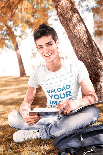 T-Shirt Mockup of a College Student Sitting on the Grass