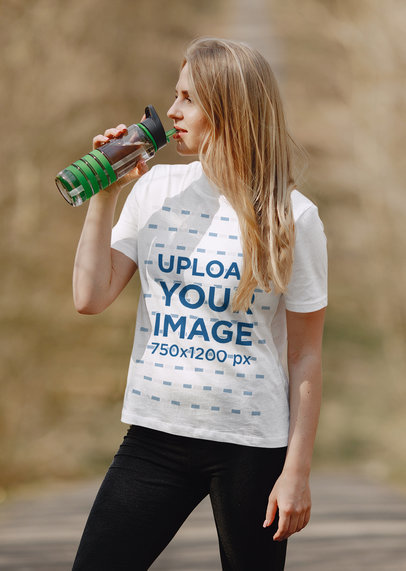 Mockup of a Woman Wearing a T-Shirt While Drinking Water at a Park