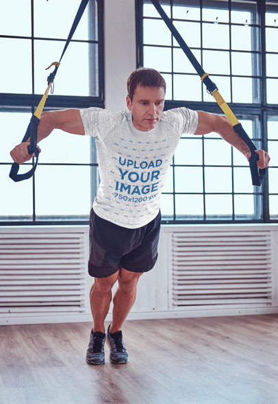 Heathered T-Shirt Mockup of a Man Training Chest at the Gym