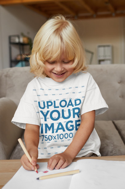 T-Shirt Mockup of a Smiling Kid Drawing at Home 