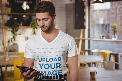 V-Neck Tee Mockup Featuring a Man Standing in a Restaurant 